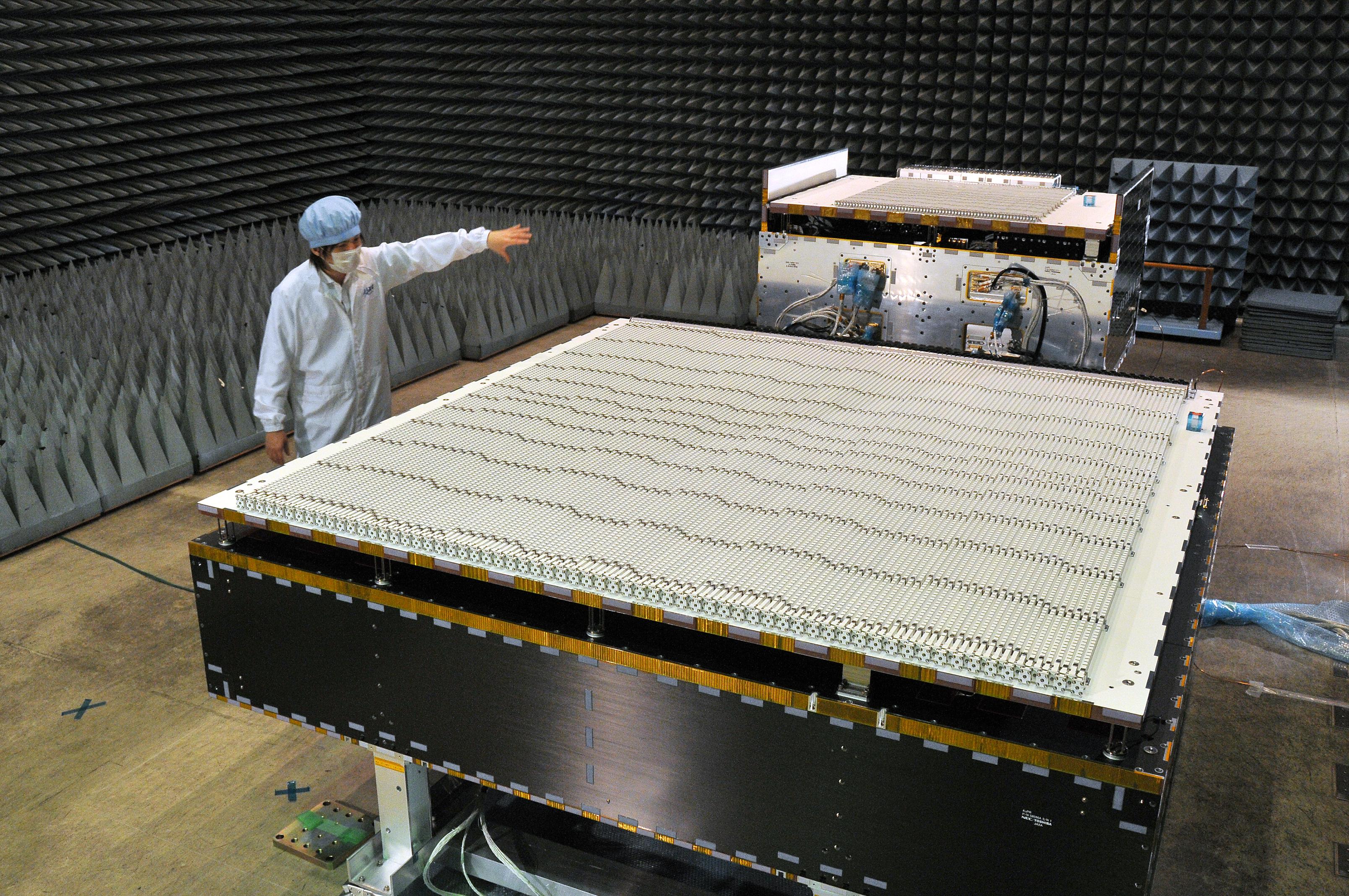 A JAXA scientist standing next to the Dual-frequency Precipitation Radar (DPR) i