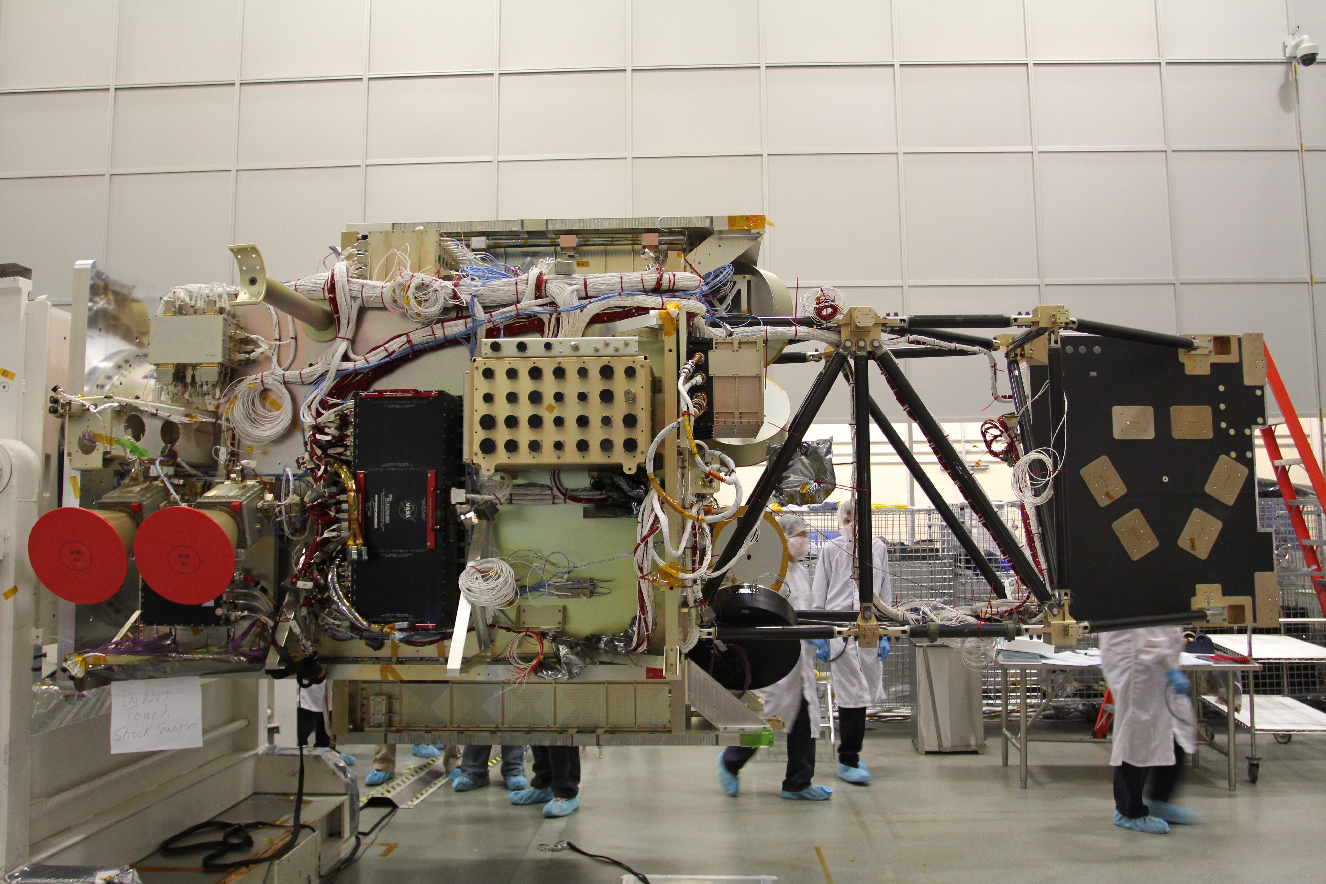 GPM satellite in a cleanroom surrounded by engineers
