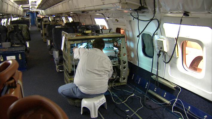 Scientist within the DC-8 preparing instruments