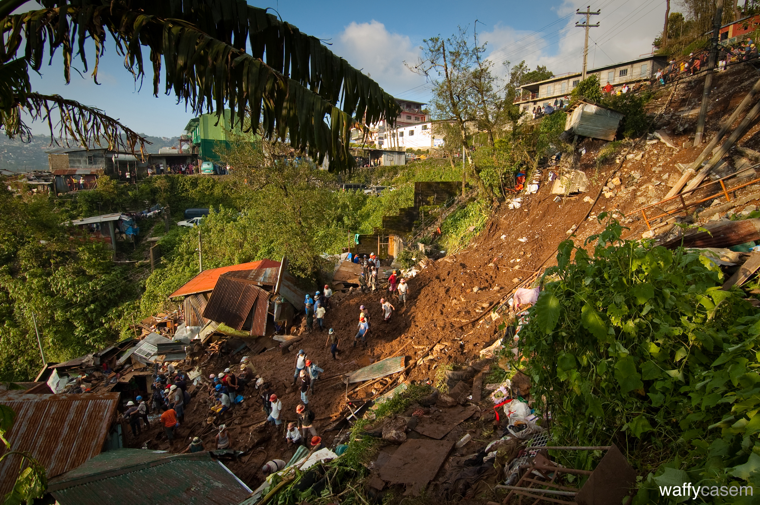 Rubble and workers in the wake of a devestating landslide in the Philippines