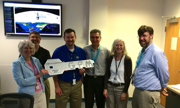 On May 29, GPM Deputy Project Manager Candace Carlisle (left) handed over the "key" to the GPM Core Observatory to GPM Mission Director James Pawloski (center, blue shirt). Also pictured, left to right, Wynn Watson, Art Azarbarzin, Gail Skofronick-Jackson and David Ward.