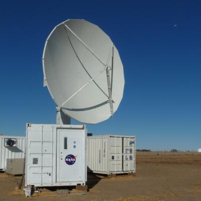 The NPOL instrument, a large radar dish attached to a trailer under a blue sky